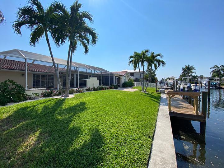 Backyard lawn and palms down to the canal
